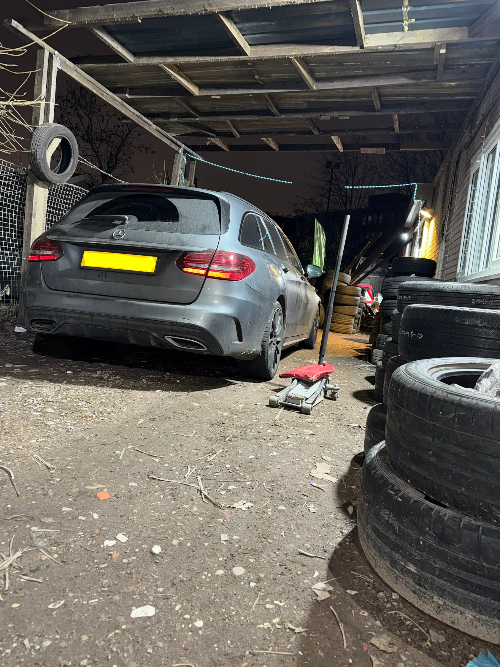 Mercedes estate at Birmingham Tyres World workshop with tyres stacked